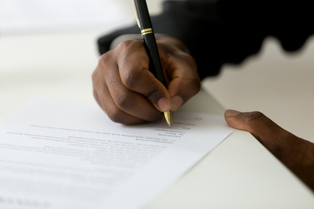 Close up of black worker signing legal documentation